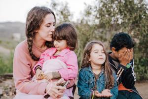 Mother and children praying together for Ukraine.
